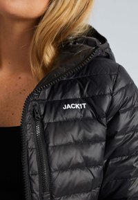 Svart puffjacka med dragkedja, featuring quiltad textur och huva. Logotypen "JACK1T" visas på den vänstra sidan fram.