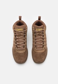 Hnědé vysoké tenisky z semiše a textilu, s designem na šněrování, polstrovaným límcem a zlatým logem K-Swiss na jazyku.