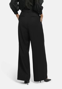 Zwarte wijde broek met een zachte textuur, met een hoge taille, zijzakken en subtiele details op de achterkant van de zakken.