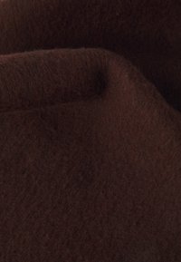 Brunt filtstof med en blød, struktureret overflade, der viser en rig, dyb farve og subtile variationer i nuancer.