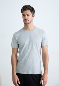 T-shirt grigio a maniche corte realizzato in morbido cotone misto, con scollatura tonda e un piccolo logo sul petto. Vestibilità semplice e informale.
