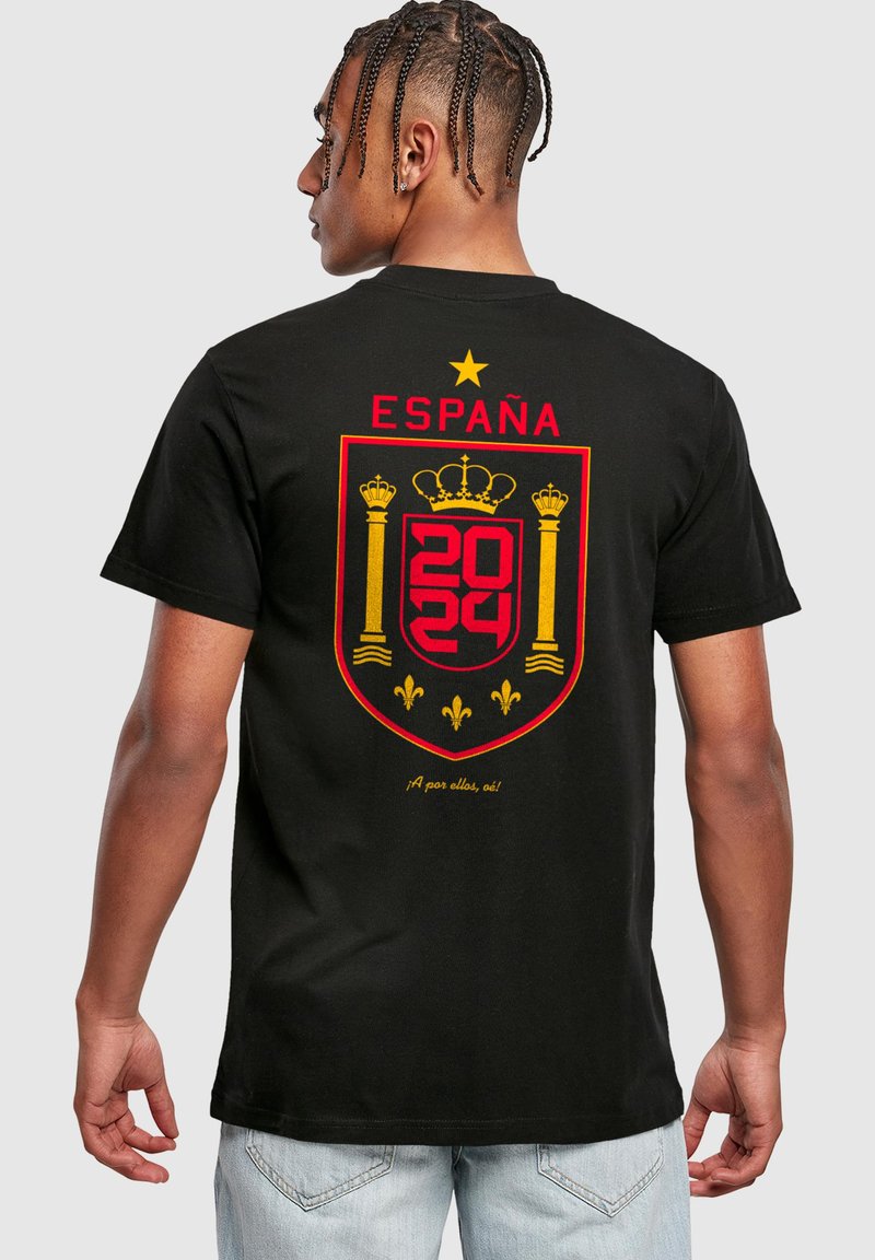 Fekete pamut póló, nagy piros és sárga Spanyolország címkével, arany koronával, "ESPAÑA 2024" felirattal és díszítő elemekkel alatta.