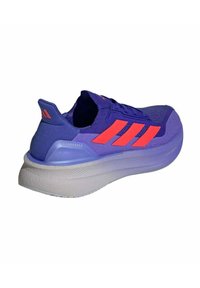 Chaussure de course violette avec des accents orange, tige en maille, semelle intermédiaire rembourrée et semelle extérieure texturée. Présente un branding à trois bandes et le détail "ULTRABOOST".