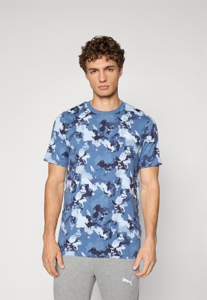 Blue camo-patterned short-sleeve t-shirt made of soft fabric, featuring a round neck and a small white logo on the chest.