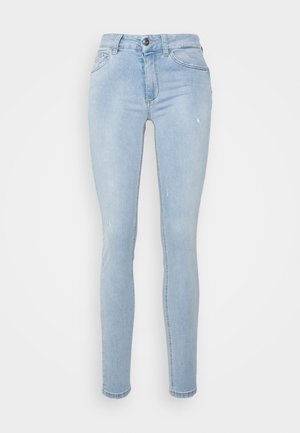 Jean skinny bleu clair avec des détails subtilement usés, poches avant, fermeture à boutons et passants de ceinture sur fond blanc.