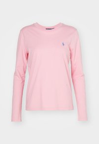 Långärmad t-shirt i mjuk rosa bomull med rund halsringning, med en liten blå logotyp på vänster bröst.