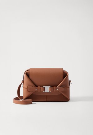 Bruine leren crossbodytas met een gestructureerd ontwerp, voorzien van een zilveren gesp en een verstelbare strap. Soepele textuur met gestikte accenten.