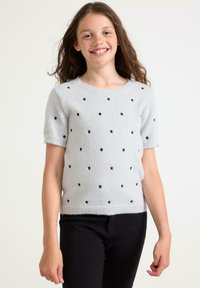Lys grå kortærmet sweater lavet af blødt stof, med sorte stjerne-mønstre over fronten og en rund halsudskæring.