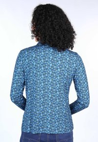Long-sleeve shirt in blue with floral pattern, featuring a fitted design, smooth texture, and a subtle collar at the neckline.