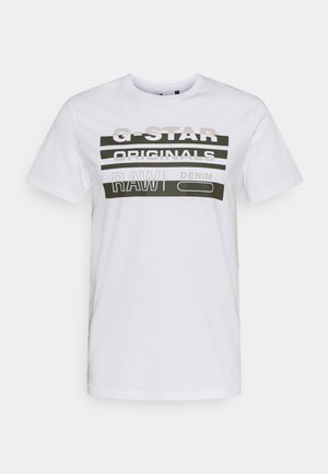 Witte T-shirt met korte mouwen met dikke zwarte en grijze tekst met "G-STAR ORIGINALS RAW DENIM" op de borst.
