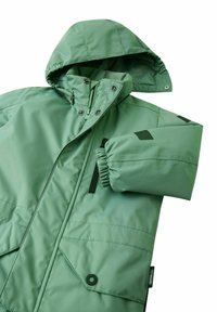 Zielona pikowana kurtka z kapturem, zapinana na zamek, z elastycznymi mankietami i dwiema dużymi przednimi kieszeniami. Posiada przyszyte detale i czarne akcenty.