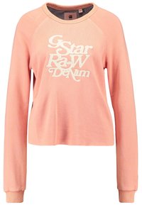 Sudadera corta rosa con mangas largas, que presenta un logo bordado en blanco de "G-Star RAW Denim" en el frontal. Tejido suave con puños acanalados.