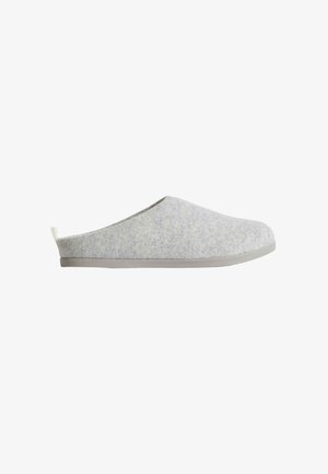 Grijze slippers van flexibel materiaal met een gladde textuur, minimalistisch ontwerp, ronde neus en een platte grijze rubberen zool. Voorzien van een klein achterlusje voor gemakkelijke instap.