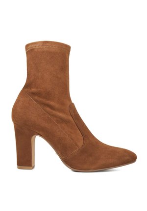 Braune Wildleder-Stiefeletten mit spitzem Zeh, mittelgroßem Blockabsatz und elastischen Seitenpaneelen für ein einfaches An- und Ausziehen. Glatte Textur mit gesteppten Akzenten.