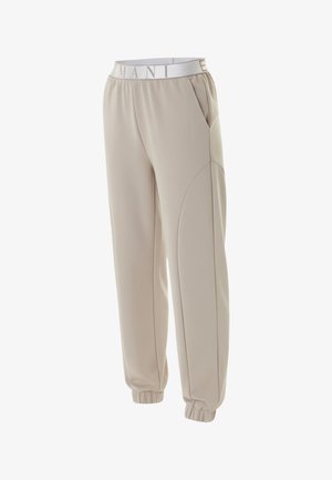Pantalones jogger beige con cintura elástica con el texto "ARMANI", bolsillos laterales y puños elásticos en los tobillos.