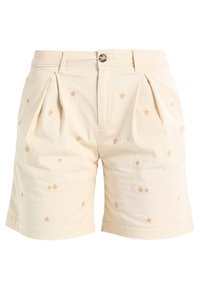 Shorts en coton beige avec des étoiles dorées brodées, un devant plissé et un bouton à la taille. Jambes droites avec ourlets à revers.