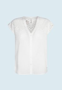 Bílá lněná blůza s výstřihem do V, krátkými rukávy ve stylu cap a dekorativní krajkou na ramenech. Zapínání na knoflíky vpředu a volný střih.