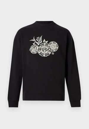 Sort langærmet sweatshirt med hvidt blomsterdesign og teksten "HUGO" i fed skrift midt på fronten.