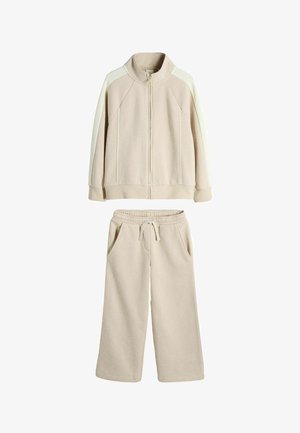 Béžová fleecová súprava so zipovou bundou s kontrastnými panelmi na rukávoch a široké nohavice so sťahovacou šnúrkou a vreckami.