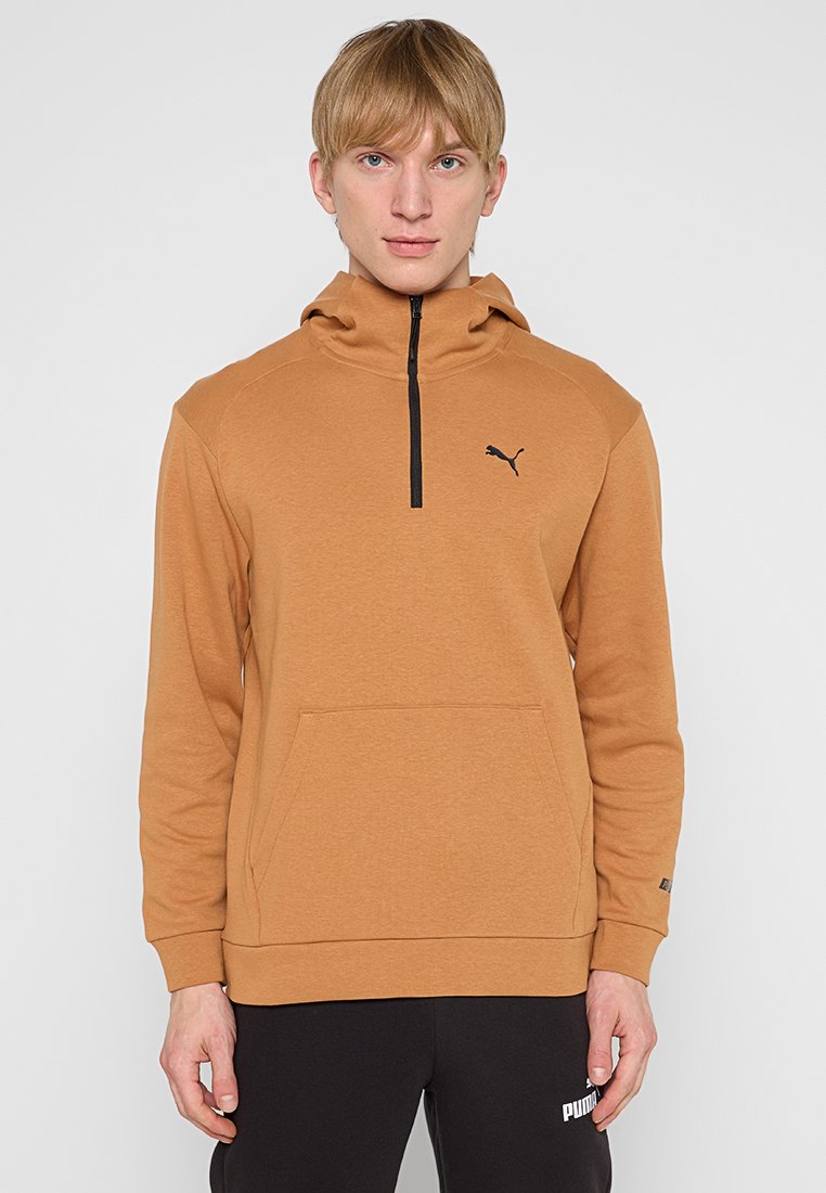 Bruine rits hoodie van zachte stof, met een voorkant zak en een zwart logo op de borst, lange mouwen en een hoge kraag.