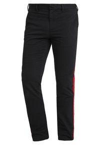 Svarta byxor med slim fit, med en röd rand längs ytterbenen. Tillverkade av ett slätt tyg med rak skärning.