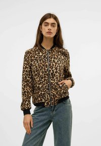 Bomberjacka i leopardmönster med dragkedja, svarta ribbade muddar och nederkant, samt sidofickor, tillverkad av lätt och mjukt tyg.