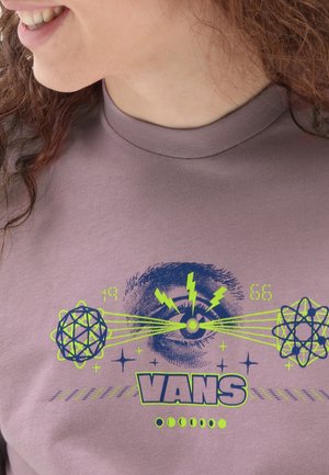 T-shirt en coton violet à col rond avec un imprimé graphique en bleu et vert fluo, comprenant des symboles scientifiques et le mot "VANS."