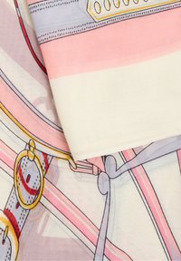Écharpe en soie présentant une palette de couleurs rose et crème avec des motifs abstraits, des formes délimitées et des accents en matériel doré.