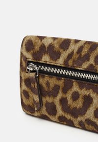 Leopard print wallet made of soft suede, featuring a black zipper closure, and dark brown accents. Flap detail with silver hardware.