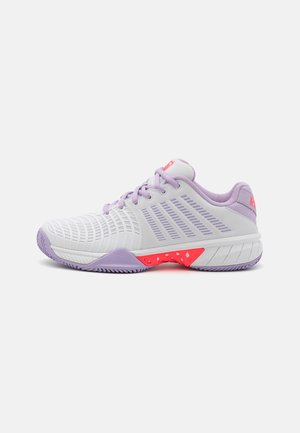 Baskets de sport violettes et blanches avec une tige en maille, un design texturé et un accent rose sur la semelle. Elles disposent d'un col rembourré et d'un système de laçage.