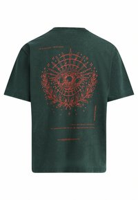 T-shirt en coton vert avec un grand graphique représentant un œil rouge accompagné d'éléments décoratifs et de texte au dos. Manches courtes, col rond, coupe décontractée.