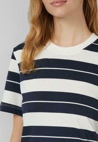 Gestreept t-shirt van katoen, met marineblauwe en witte horizontale strepen, ronde halslijn en korte mouwen met zichtbare stikseldetails.