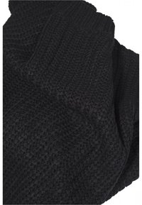 Schwarzer Strickstoff mit gerippter Textur, der ein lockeres, asymmetrisches Design aufweist. Das Material scheint weich und dick zu sein, ideal für Wärme.