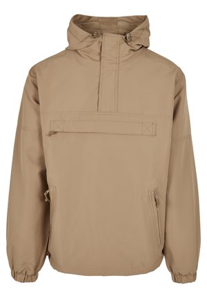 Chaqueta de pullover con capucha en color beige, con bolsillo frontal con cremallera, puños elásticos y forro de malla transpirable. Fabricada en un tejido ligero y resistente al agua.
