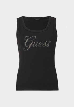 Melns ribots bezroku tops ar lieli izgriezumu, uz kura rakstīts "Guess" ar rhinestones un zemāk mazākiem burtiem "est. 1981".