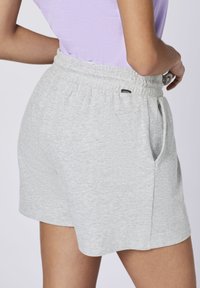 Gray knit shorts with an elastic waistband, side pockets, and a tag on the back. The fabric has a textured finish.