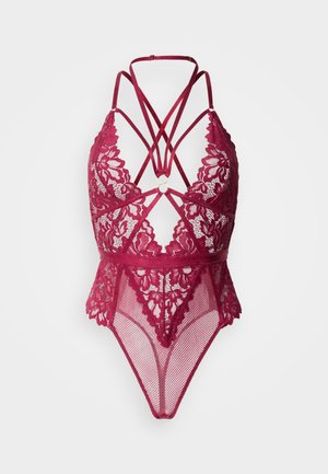 Body en dentelle bordeaux et mesh, avec un décolleté plongeant en V, des bretelles croisées, des motifs floraux et une finition transparente et légèrement translucide.