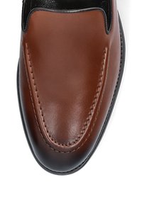 Brązowy skórzany but wsuwany o gładkim wykończeniu, z przeszyciami i zaokrąglonym noskiem. Czarne akcenty przy otworze i podeszwie.