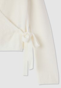 Maglione avvolgente bianco realizzato in tessuto morbido, con chiusura a laccio sul lato sinistro e polsini a coste sulle maniche.