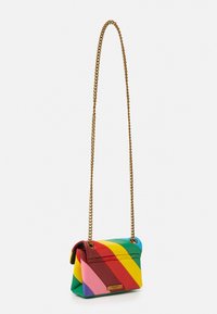 Piccola borsa rettangolare con strisce diagonali arcobaleno e lunga tracolla in oro su uno sfondo bianco semplice.