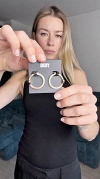 Σκουλαρίκια κρίκοι σε χρυσό τόνο πάνω σε μαύρη κάρτα παρουσίασης, με λείο, στρογγυλεμένο σχήμα και γυαλιστερό φινίρισμα. Το λογότυπο της μάρκας είναι ορατό στην κορυφή.