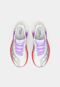 Scarpe athletic leggere con una tomaia in mesh bianco, accenti viola sui lacci e una suola rossa. Caratterizzate da dettagli laterali a motivo.