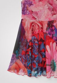 Sukienka w kwiatowy wzór z dopasowanym górnym fasonem i plisowanym przezroczystym dołem. Charakteryzuje się intensywnymi kolorami, w tym różowym, czerwonym, niebieskim oraz czarnymi akcentami.