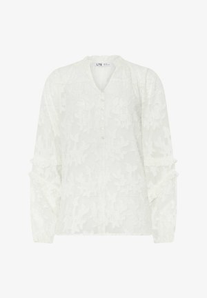 Blusa blanca de manga larga con patrón floral texturizado, tapeta de botones y detalles de mangas con volantes. Corte ligeramente relajado.