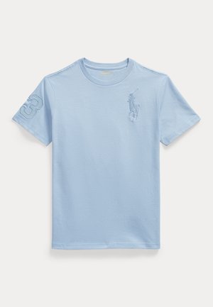 Tricou din bumbac albastru deschis, cu mâneci scurte. Prezintă un număr 3 și un logo cu un jucător de polo brodat în nuanțe tonale pe piept și pe mânecă.