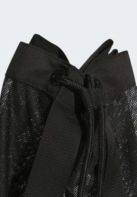 Zwarte mesh tas met een trekkoordsluiting, met een textuurstof en een gladde band. Het ontwerp bevat kleine perforaties overal.