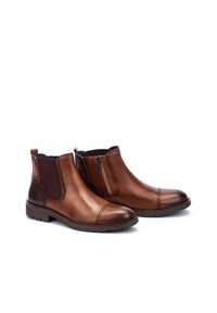 Botas de cuero marrón hasta el tobillo con un acabado suave, paneles laterales elásticos, cremallera lateral y diseño de puntera redondeada. Suelas planas y texturizadas.