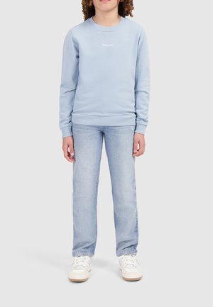 Lichtblauw sweatshirt met geribde mouwen en halslijn, voorzien van witte tekst. Gepaard met lichtblauwe recht-toe-rechtaan jeans en witte schoenen.