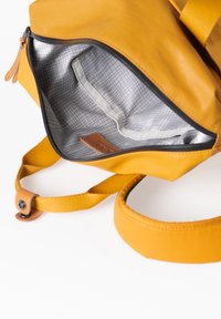 Gelbe Tasche aus glattem Leder, mit einem grau karierten Innenleben, Reißverschluss und braunen Lederakzenten an den Riemen.