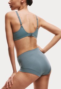 Set di reggiseno senza cuciture e mutandine a vita alta di un azzurro chiaro. Tessuto morbido e elastico con spalline regolabili e chiusura a gancio sul retro.